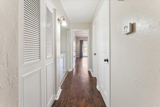 corridor with baseboards, dark wood-style floors, and a textured wall