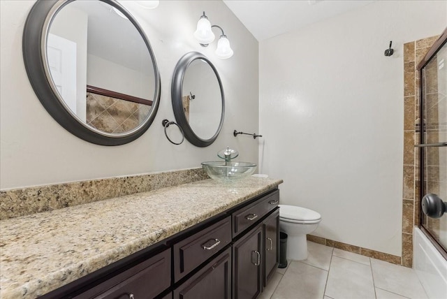 bathroom with tile patterned floors, toilet, combined bath / shower with glass door, baseboards, and vanity