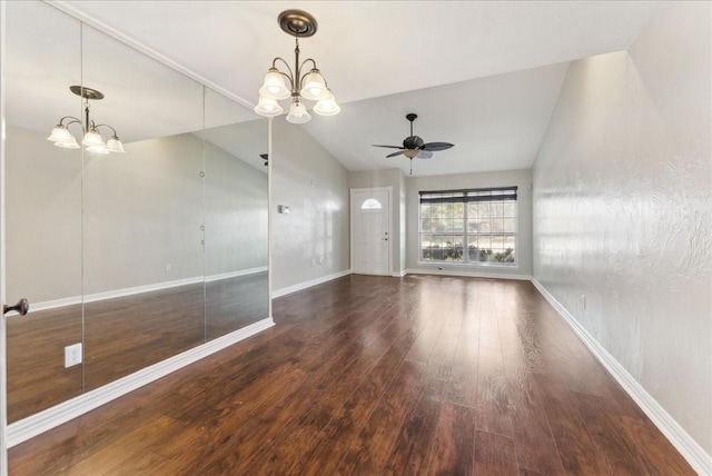 unfurnished living room with ceiling fan with notable chandelier, baseboards, lofted ceiling, and wood finished floors