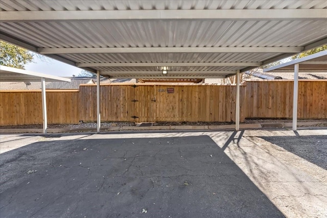 covered parking lot featuring fence