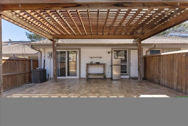 view of patio featuring central AC, a pergola, and fence