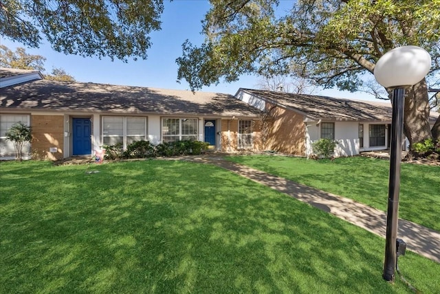 ranch-style home with brick siding, an attached garage, and a front lawn