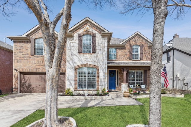 view of front of house featuring an attached garage, brick siding, concrete driveway, stone siding, and a front yard