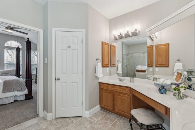 ensuite bathroom featuring a ceiling fan, connected bathroom, a shower stall, vanity, and baseboards