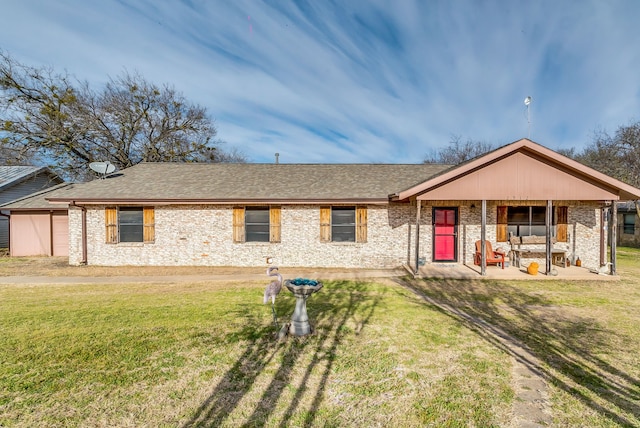 ranch-style house with brick siding, a front lawn, and roof with shingles