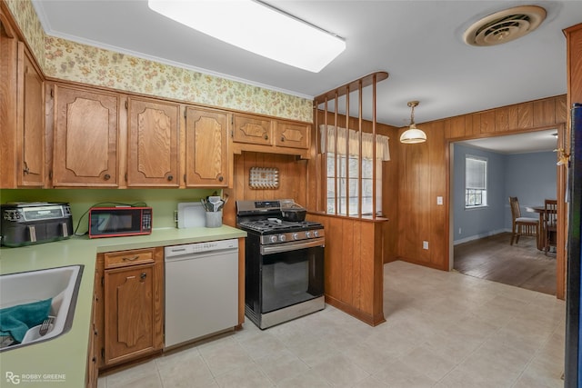 kitchen with light countertops, visible vents, brown cabinetry, stainless steel range with gas stovetop, and white dishwasher