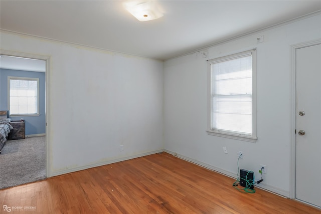 spare room with baseboards and wood finished floors