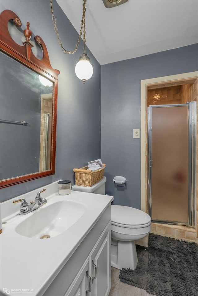 full bathroom with toilet, a stall shower, and vanity