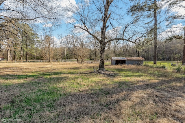 view of yard with a storage unit, fence, and an outdoor structure