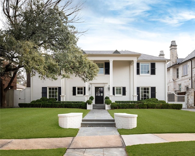 neoclassical / greek revival house with stucco siding and a front yard