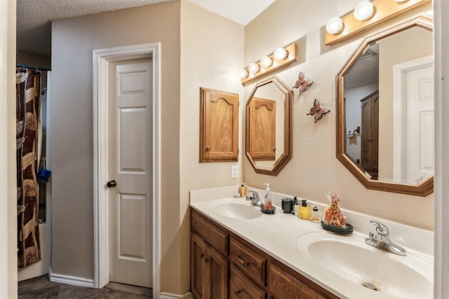 1579 County Road 2008 Unit F, Glen Rose, TX 76043 - bathroom featuring a sink, a textured ceiling, and double vanity
