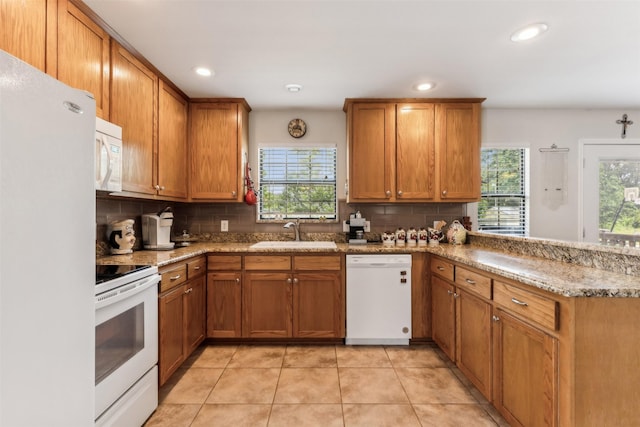 1579 County Road 2008 Unit F, Glen Rose, TX 76043 - kitchen featuring white appliances, a peninsula, a sink, brown cabinets, and backsplash