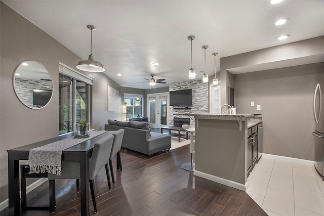 kitchen featuring pendant lighting, dark wood-type flooring, a breakfast bar, and light stone countertops