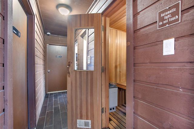 interior space with wooden walls and visible vents