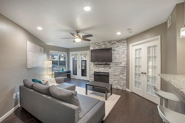 living room featuring french doors, a fireplace, dark wood finished floors, and baseboards