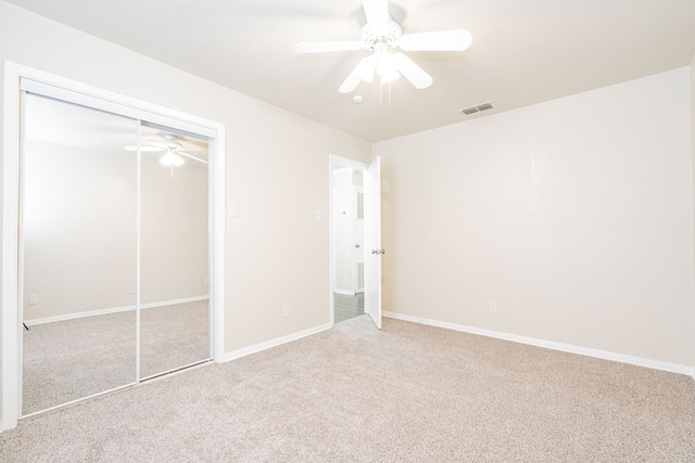 unfurnished bedroom featuring a closet, visible vents, a ceiling fan, carpet flooring, and baseboards