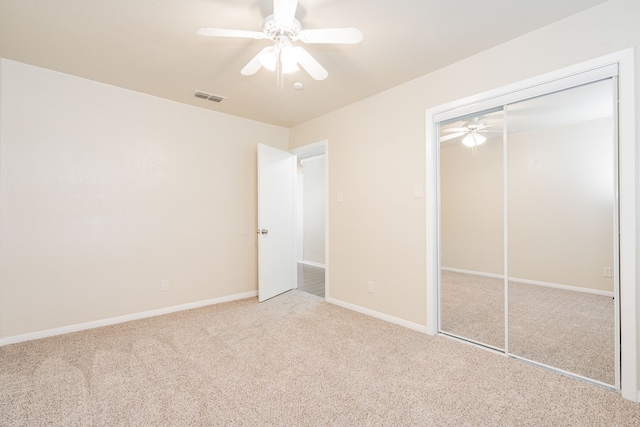 unfurnished bedroom featuring baseboards, visible vents, a ceiling fan, carpet floors, and a closet