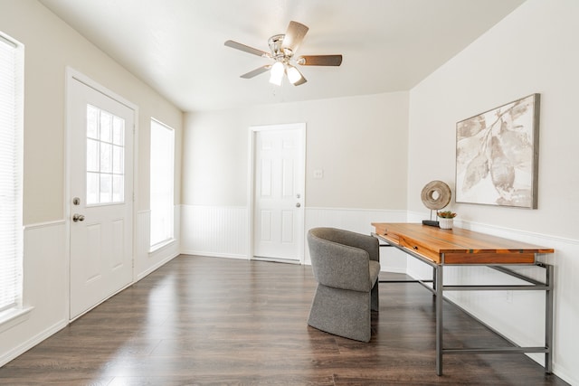 office space with a wainscoted wall, ceiling fan, and dark wood finished floors