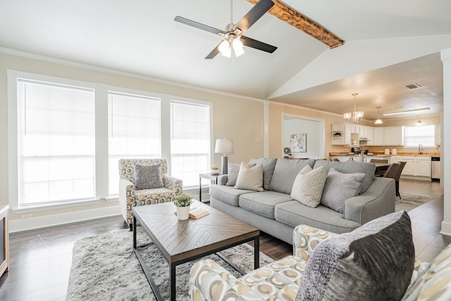 living area with visible vents, baseboards, ornamental molding, vaulted ceiling with beams, and ceiling fan with notable chandelier