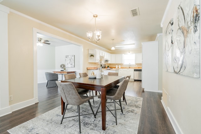 dining room featuring dark wood-type flooring, visible vents, and crown molding