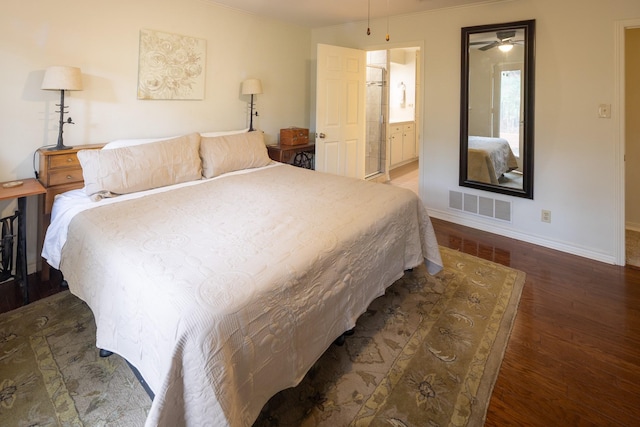 bedroom with visible vents, connected bathroom, baseboards, and wood finished floors