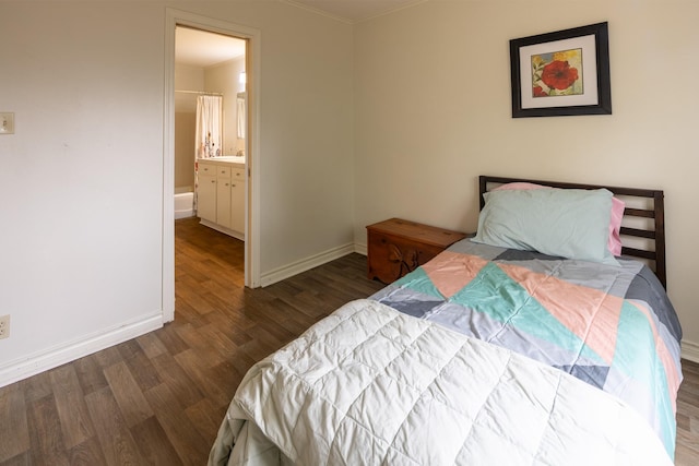 bedroom featuring a sink, wood finished floors, connected bathroom, and baseboards