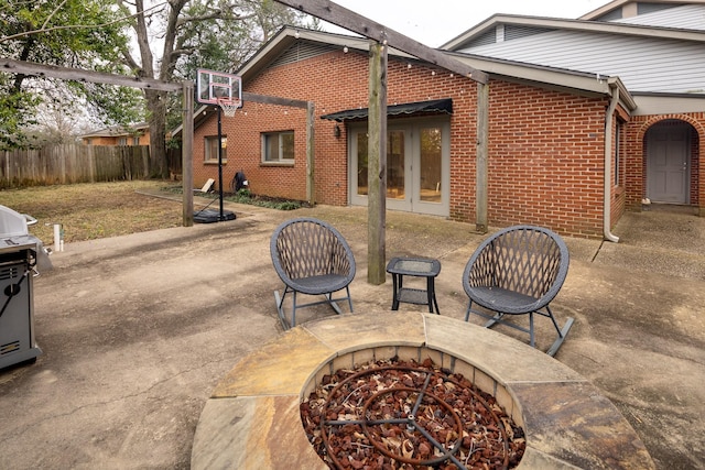 view of patio featuring an outdoor fire pit, french doors, and fence