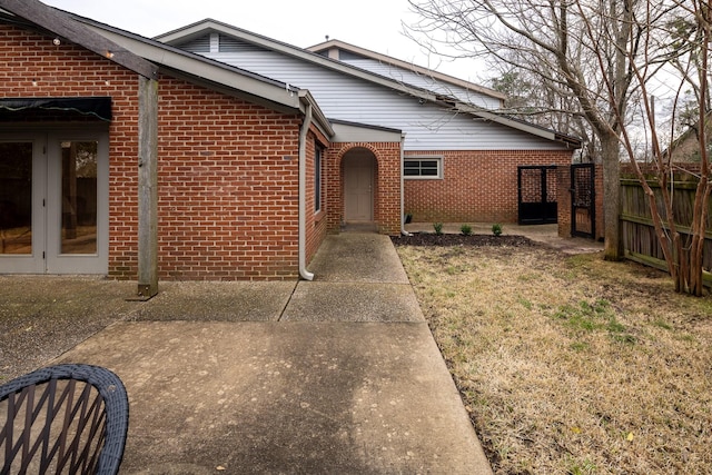 view of front of home featuring brick siding and fence