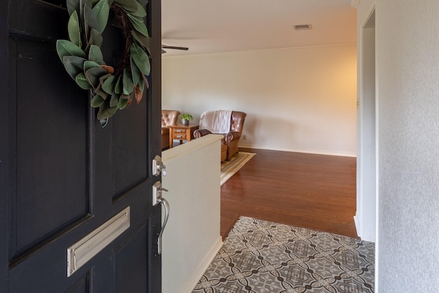 entrance foyer with a ceiling fan, wood finished floors, visible vents, and baseboards