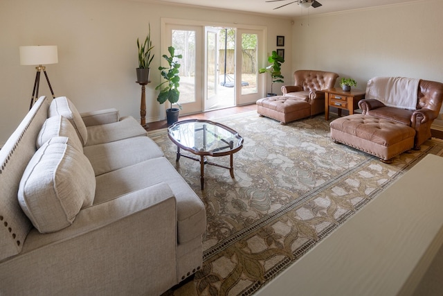 living room with a ceiling fan, crown molding, and wood finished floors