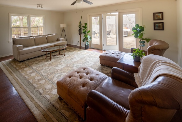 living room with a healthy amount of sunlight, crown molding, baseboards, and wood finished floors