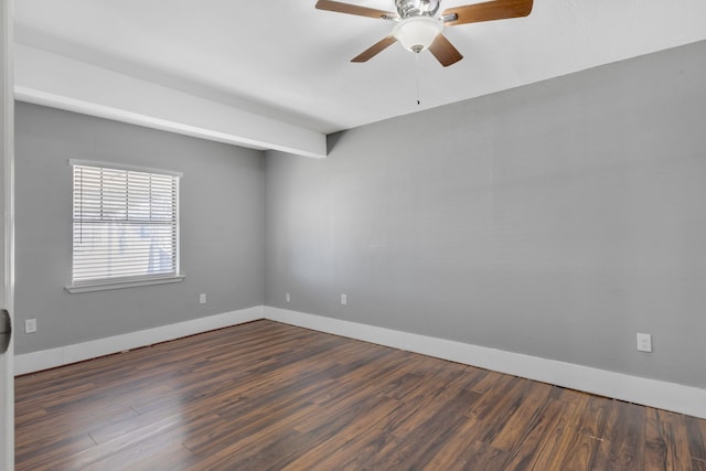 spare room with ceiling fan, dark wood-type flooring, and baseboards