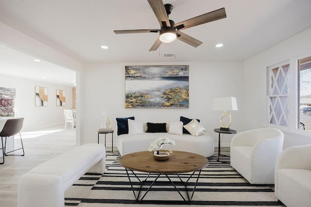 living area featuring baseboards, visible vents, ceiling fan, and recessed lighting