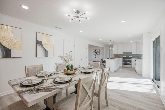 dining area featuring visible vents, light wood-style flooring, ornamental molding, an inviting chandelier, and recessed lighting