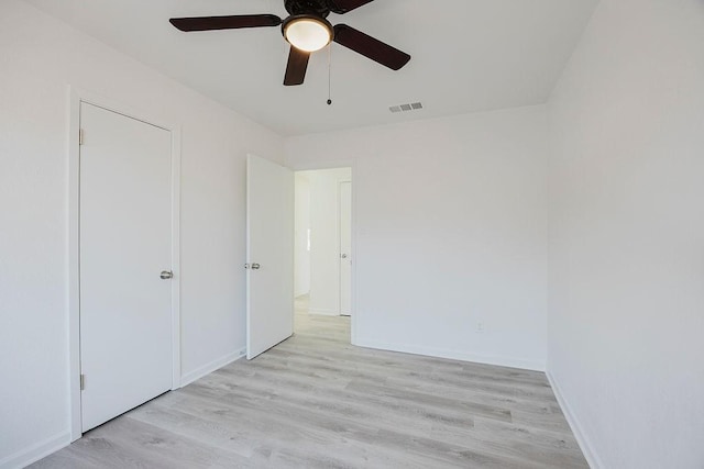 unfurnished bedroom with ceiling fan, light wood-type flooring, visible vents, and baseboards