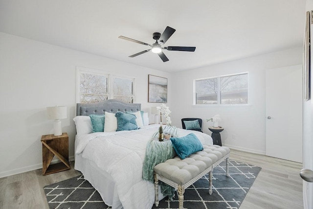 bedroom with a ceiling fan, baseboards, and wood finished floors