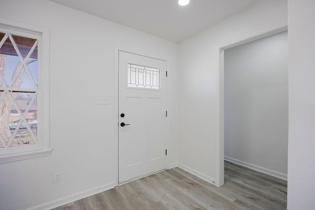 foyer with light wood-style flooring and baseboards