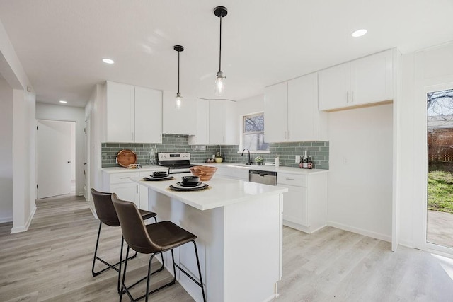 kitchen featuring stainless steel appliances, backsplash, and light countertops