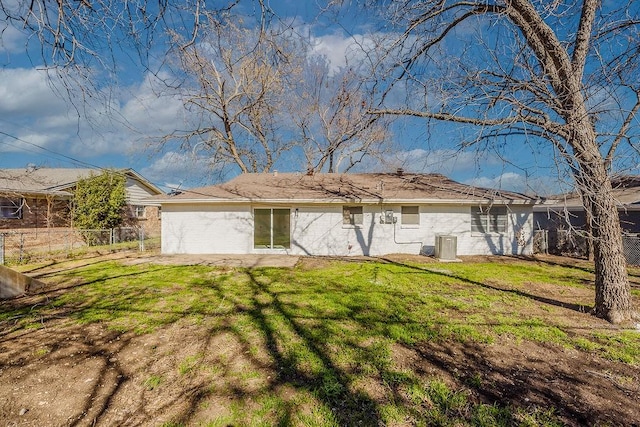 rear view of property with brick siding, fence, and a yard