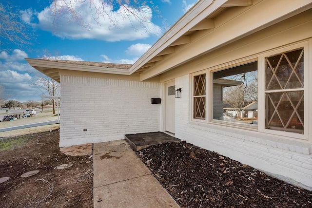 property entrance featuring brick siding