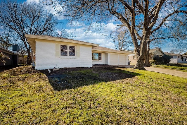 ranch-style home featuring a garage, concrete driveway, brick siding, and a front lawn