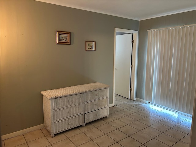 unfurnished bedroom with light tile patterned floors, ornamental molding, and baseboards