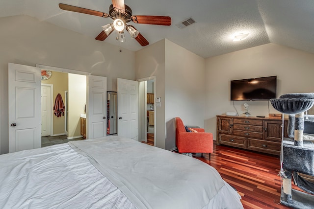 bedroom with visible vents, a ceiling fan, lofted ceiling, wood finished floors, and ensuite bathroom