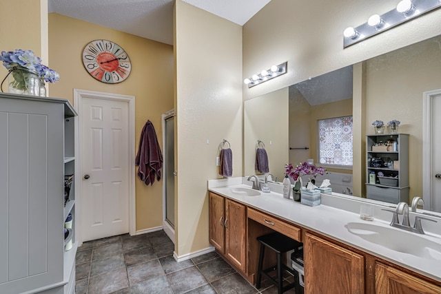 full bathroom with a stall shower, a sink, and double vanity