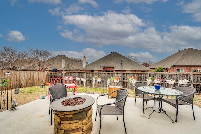 view of patio featuring fence, a fire pit, and outdoor dining space