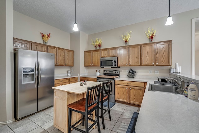 kitchen featuring light tile patterned floors, stainless steel appliances, a sink, and light countertops