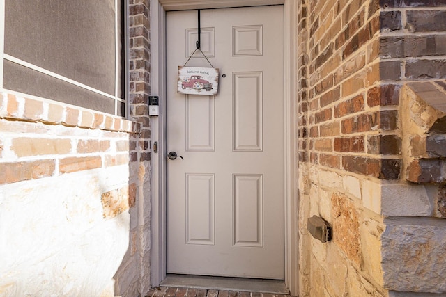 view of exterior entry with brick siding