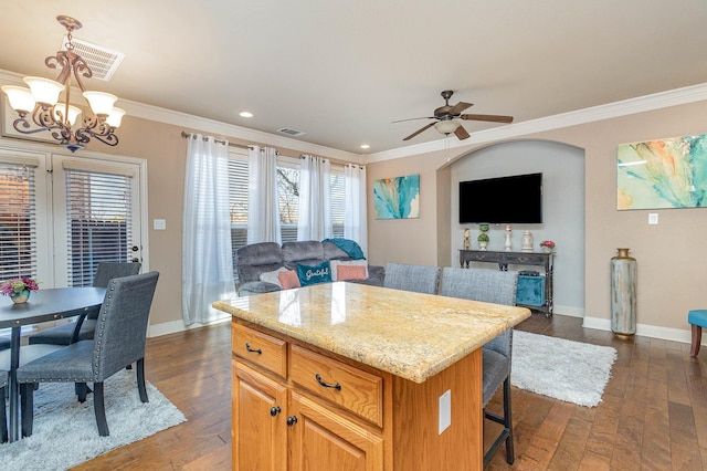 kitchen with a center island, open floor plan, visible vents, and crown molding