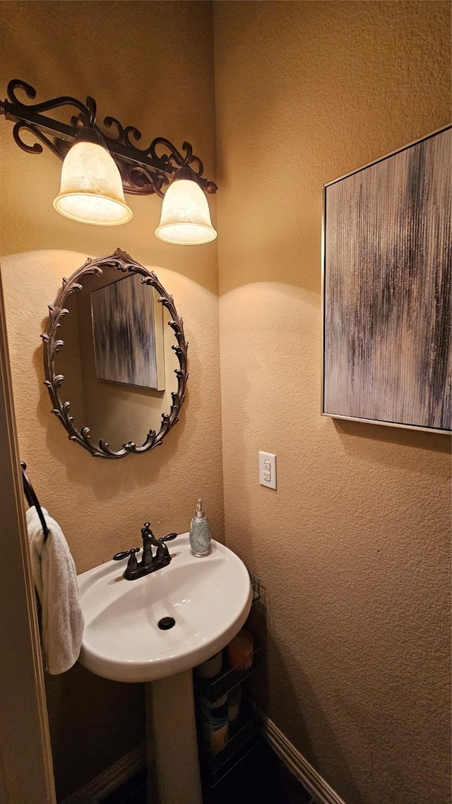 bathroom with baseboards and a textured wall