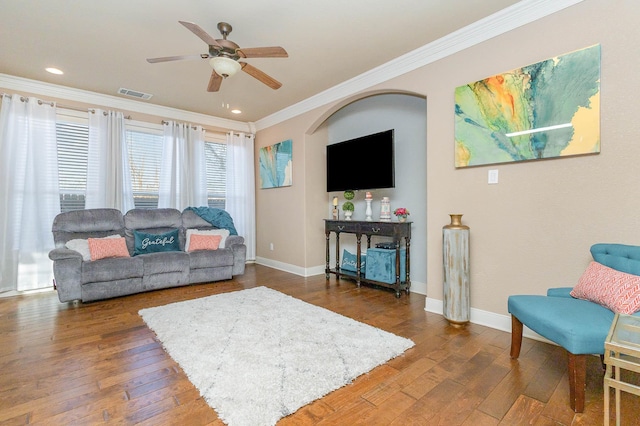 living room featuring baseboards, visible vents, hardwood / wood-style flooring, ceiling fan, and ornamental molding